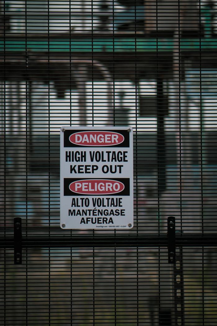 The Art of Drawing Readers In: Your attractive post title goes here Close-up of a warning sign on a metal fence indicating high voltage danger.